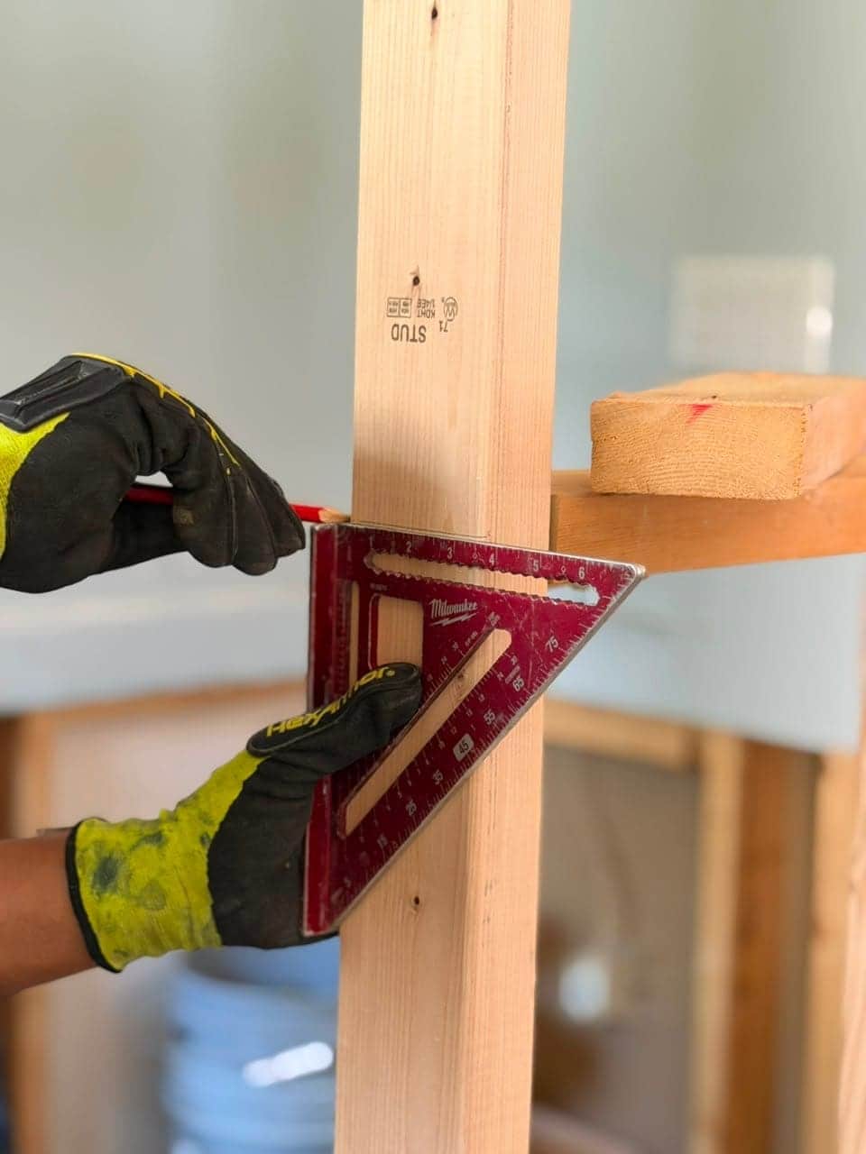 Worker measuring lumber with precision tools on site