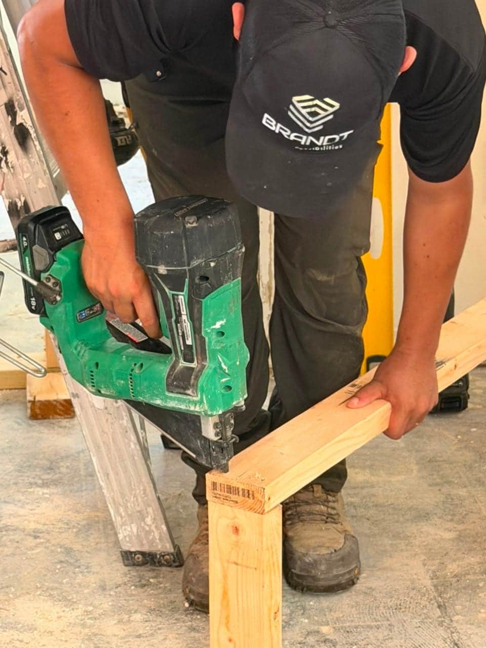 Brandt crew member framing with a nail gun